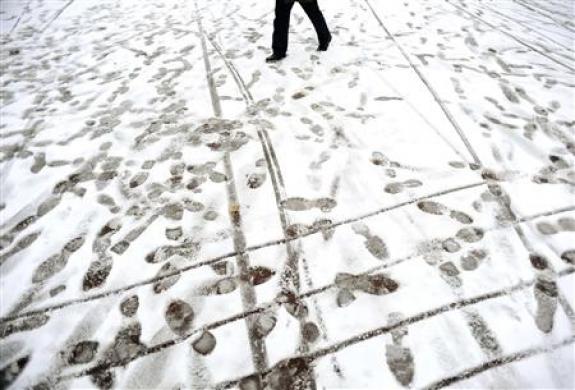 A man strolls down a snow covered street in central London December 2, 2010. REUTERS/Dylan Martinez